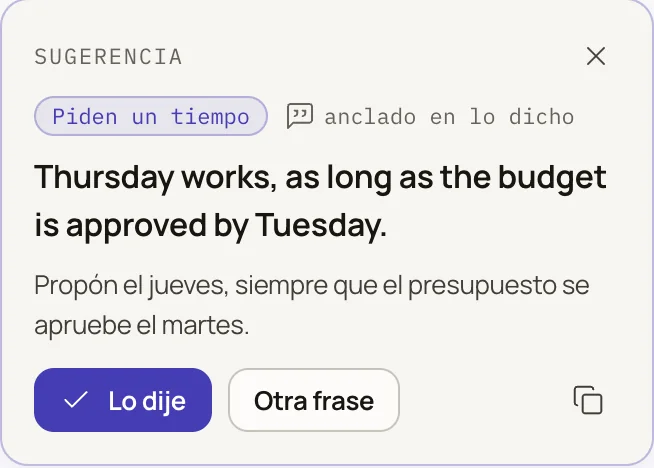 Coach suggestion in an English meeting: Thursday works, as long as the budget is approved by Tuesday. Below it, a short explanation in Spanish.